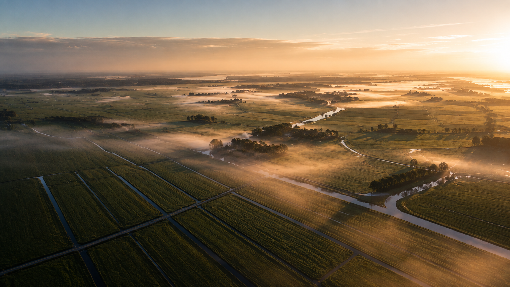 Aerial view of Dutch polder meadows at sunrise, low mist over ditches and fields